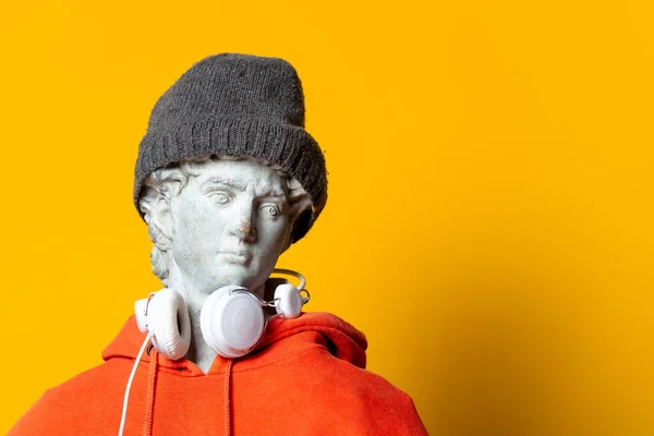 Teen Sculpture Orange Hoodie Headphones Yellow Background — Stock Photo, Image