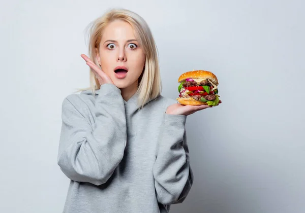 Zaskoczona Blondynka Dziewczyna Burgerem Białym Tle — Zdjęcie stockowe