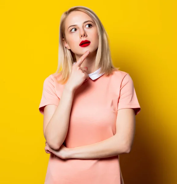 Překvapená Blondýna Dívka Růžových Šatech Žlutém Pozadí — Stock fotografie