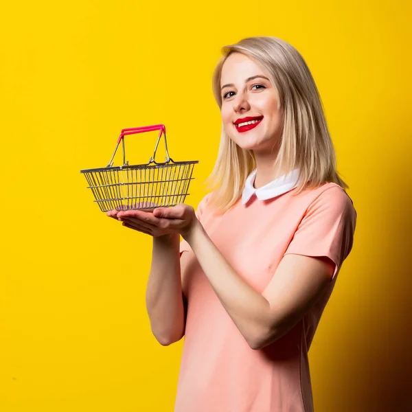 Blondýny Dívka Růžových Šatech Nákupním Košíku Žlutém Pozadí — Stock fotografie
