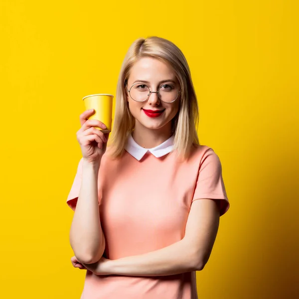 Menina Loira Vestido Rosa Com Copo Papel Fundo Amarelo — Fotografia de Stock