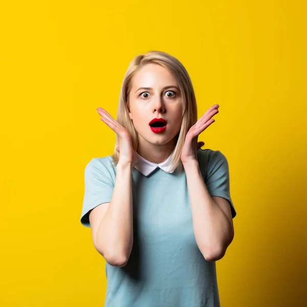 Menina Loira Surpreso Vestido Azul Fundo Amarelo — Fotografia de Stock