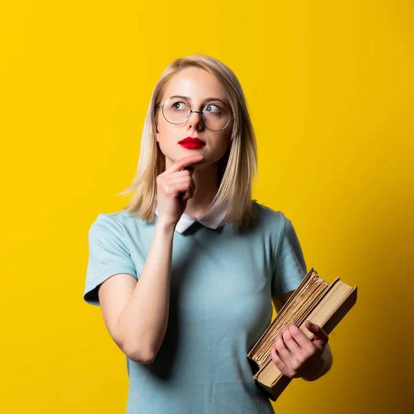 Blondynka Niebieskiej Sukience Okulary Książkami Żółtym Tle — Zdjęcie stockowe