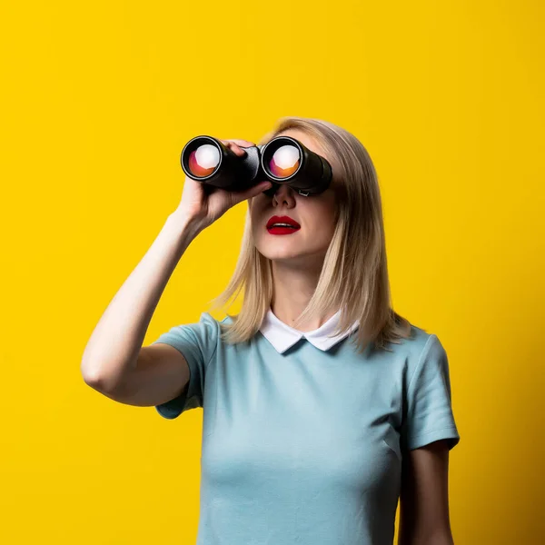 Ragazza Bionda Abito Blu Guardando Binocolo Sfondo Giallo — Foto Stock