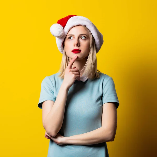 Ξανθιά Κοπέλα Μπλε Φόρεμα Και Άγιος Βασίλης Καπέλο Κίτρινο Φόντο — Φωτογραφία Αρχείου