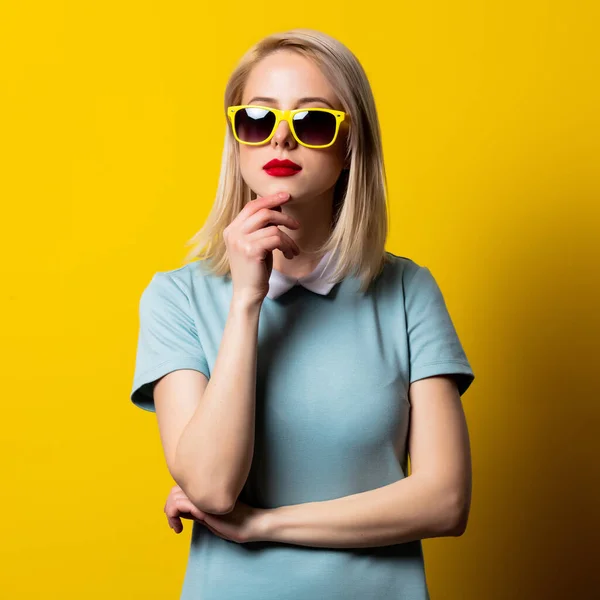 Menina Loira Óculos Sol Vestido Azul Fundo Amarelo — Fotografia de Stock