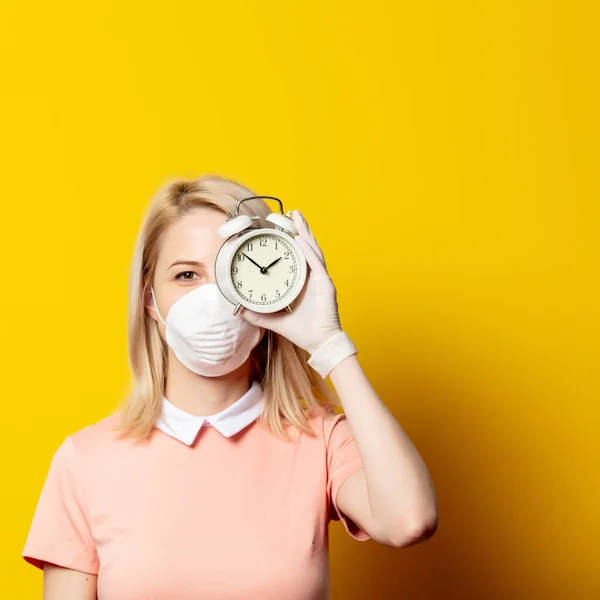Sarı Arka Planda Çalar Saati Olan Maskeli Sarışın Kız — Stok fotoğraf