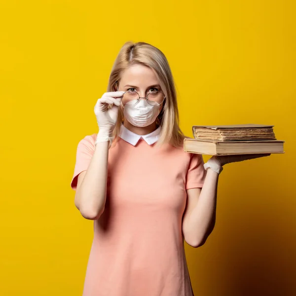 Блондинка Масці Обличчя Рожева Сукня Тримає Книгу Жовтому Тлі — стокове фото