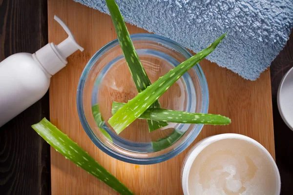 Aloe vera yaprakları ve uçucu yağ ahşap arka plan üzerinde kapat.