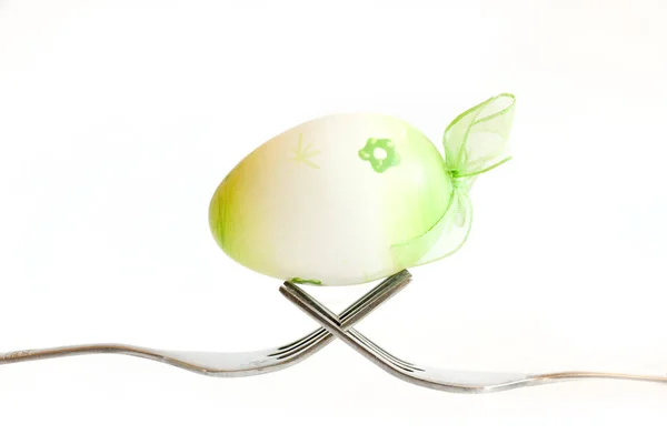 Paskalya yortusu yumurta beyaz zemin üzerine çatal üzerinde tutulması — Stok fotoğraf