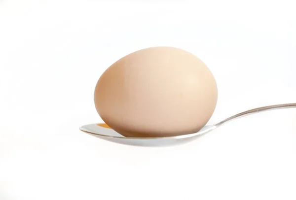 Húsvéti tojás tartani az evőeszköz, fehér alapon — Stock Fotó