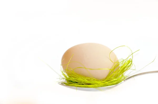 Пасхальное яйцо хранится на столовых приборах на белом фоне — стоковое фото