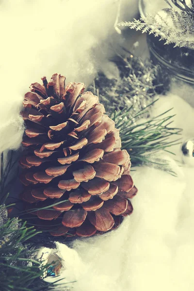 Elegante Weihnachtsdekoration mit Tannenzapfen und grünem Tannenzweig — Stockfoto