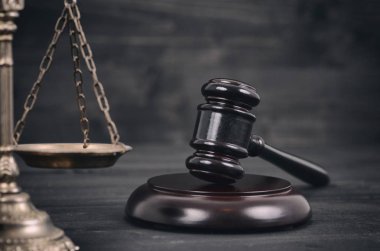 Adalet ölçekler ve yargıç tokmak siyah ahşap zemin.