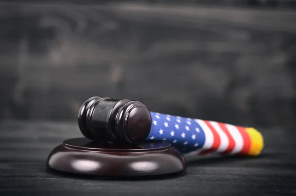黒い木製の背景に裁判官小槌とアメリカ合衆国の旗. — ストック写真