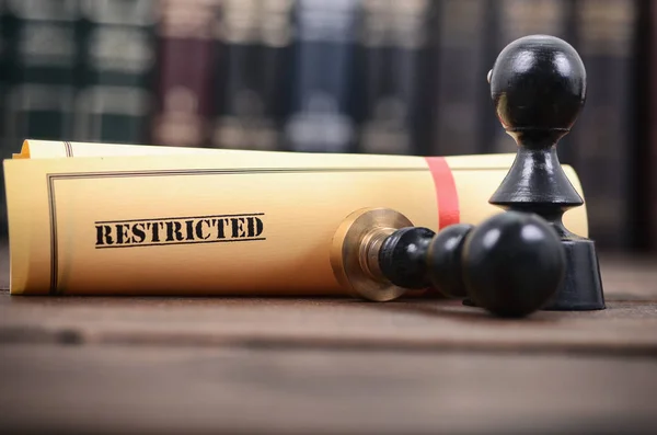 Restricted document and notary seal on the wooden background.