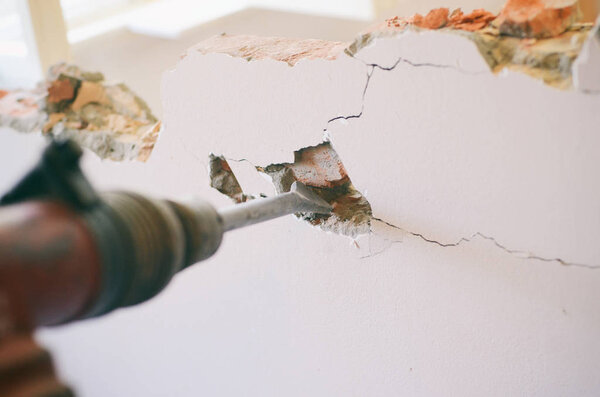 Профессиональный рабочий на строительной площадке с помощью отбойного молотка
