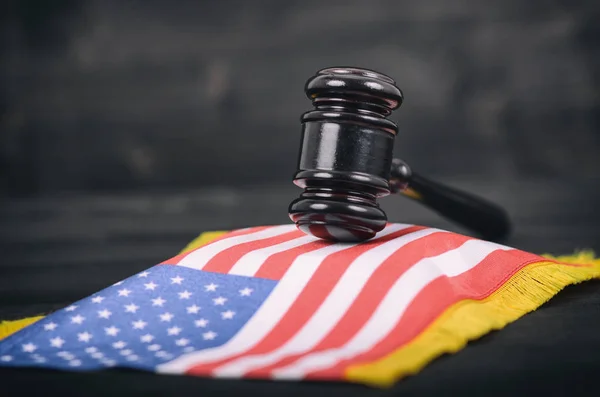 黒い木製の背景に裁判官小槌とアメリカ合衆国の旗 — ストック写真