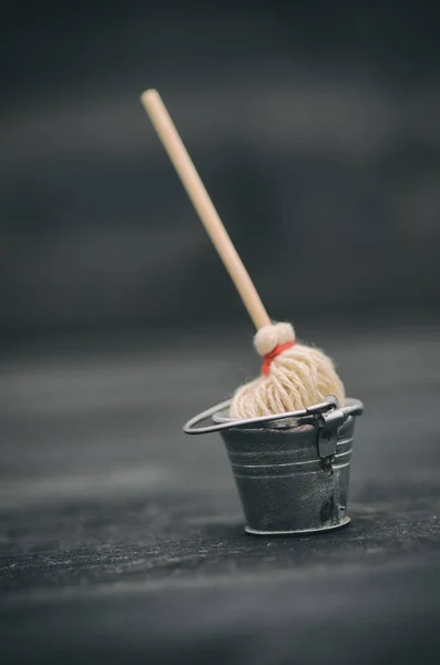 Metal bucket and mop, bucket and broom on black wooden background — Stock Photo, Image