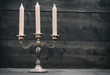 Şamdan, siyah ahşap arka planda eski gümüş mum tutacağı.