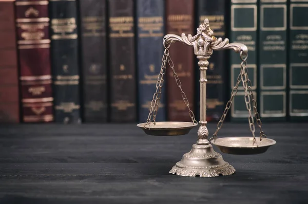 Scales of Justice on a black wooden background. — Stock Photo, Image