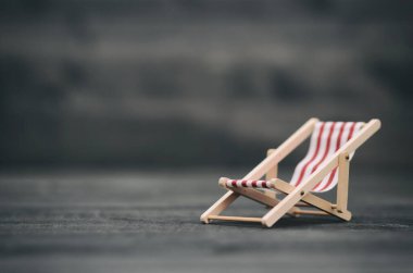 Katlanan kanvas güneş şezlonglu sandalye siyah ahşap arka planda