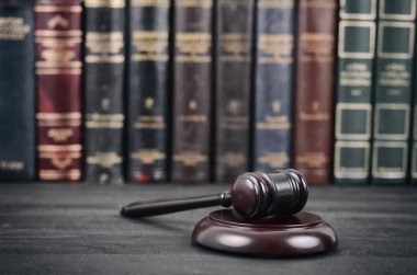 Hukuk ve adalet, yasallık kavramı, Yargıç Gavel hukuk kütüphanesi önünde siyah ahşap zemin.