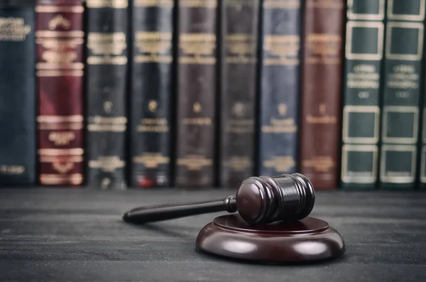 法律与正义 合法性观念 法官在法律图书馆面前的黑木背景下的槌 图库图片