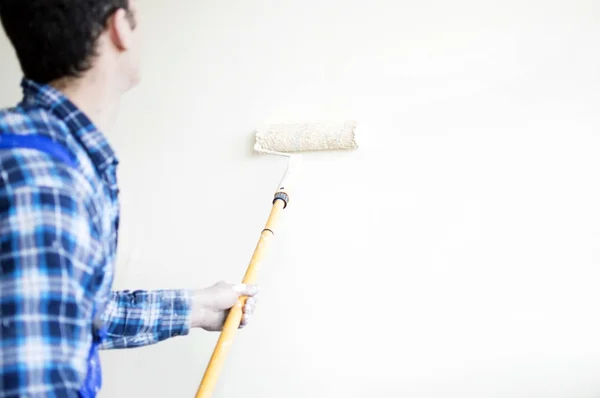 Trabajador pintor de casa pinta una pared — Foto de Stock