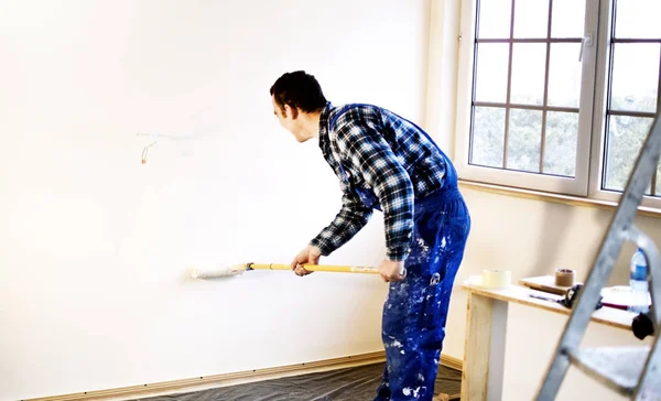 Werknemer huisschilder de muren in het wit geschilderd — Stockfoto