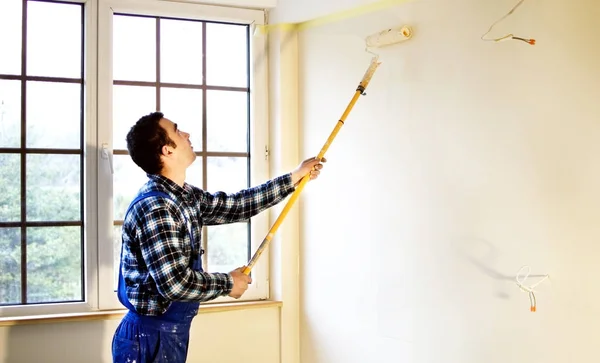 Trabajador pintor de casa pintó las paredes en amarillo —  Fotos de Stock