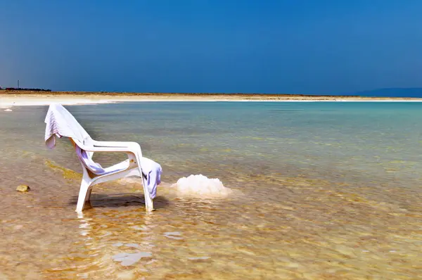 Witte stoel in het water van de dode zee — Stockfoto