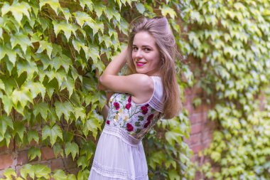 Kız bir duvar ile yeşil yeşillik zemin üzerine