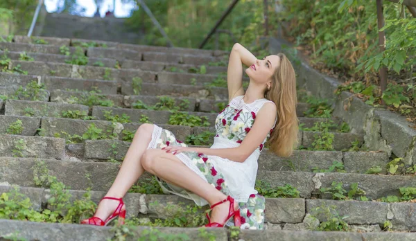 Menina bonita sentada em degraus de pedra — Fotografia de Stock