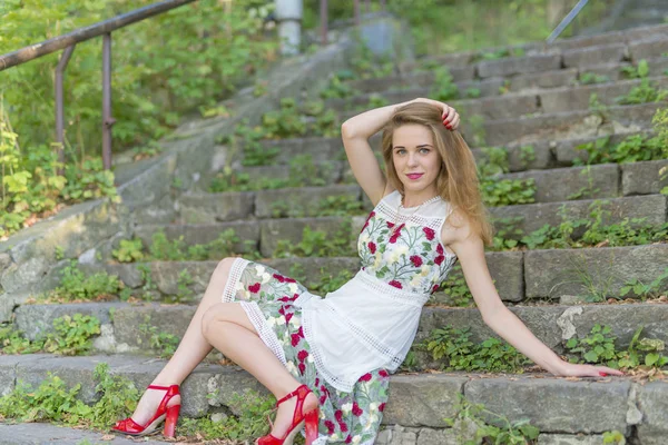 Menina bonita sentada em degraus de pedra — Fotografia de Stock