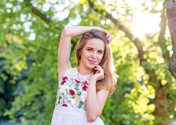 Beautiful girl posing in the street on the background of green t — Stock Photo, Image