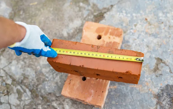 The process of measuring the size of red bricks using roulette — Stock Photo, Image