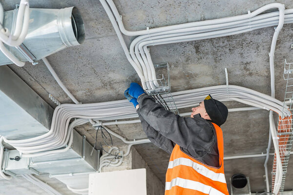 Процесс монтажа зажимов для гофрированной проволоки с кабелем в бетонном потолке
