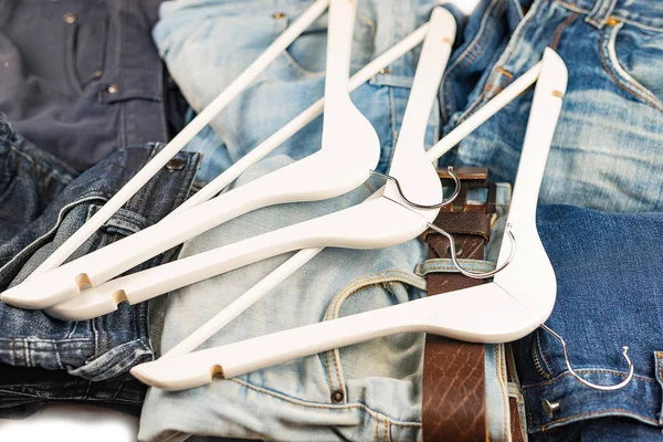 Jeans e cabides masculinos azuis e claros diferentes — Fotografia de Stock