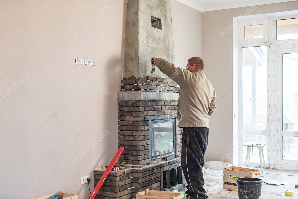 The process of installing the tile on the surface of the fireplace in the house