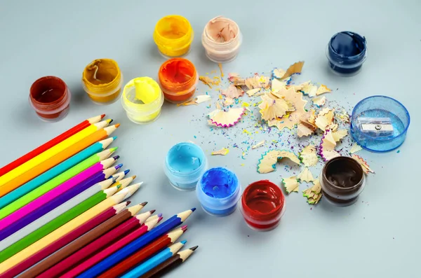 Buntstifte und Gläser mit Farbe auf grauem Grund — Stockfoto