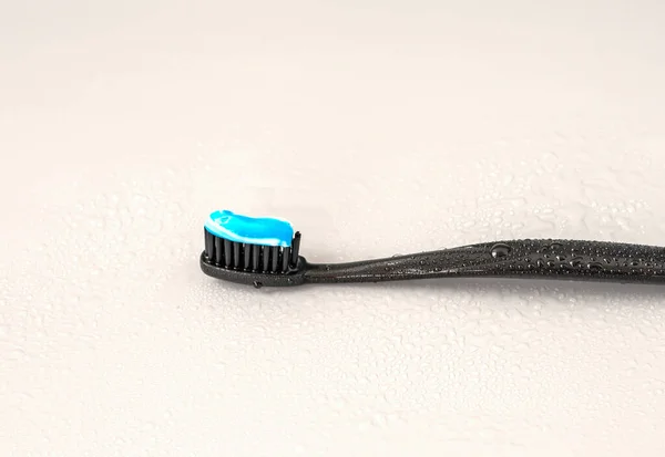 Black Toothbrush Blue Toothpaste Gray Background — Stock Photo, Image