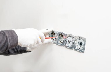 Beyaz alçı duvar arka planına elektrik, internet ve televizyon için dahili soketler kurma süreci