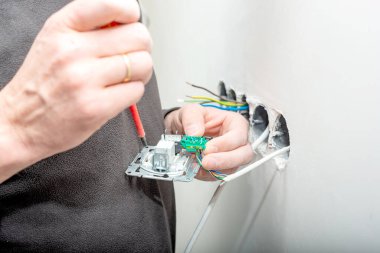 Beyaz alçı taşı duvarının arka planına internet erişimi için bir dahili soket kurma süreci