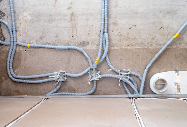 Plastic junction boxes and cable in the corrugation on the concrete ceiling