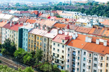 Kırmızı çatıları olan antik evler, bir sürü yeşil ağaç ve bir demiryolu, üst manzara.