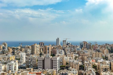Yüksek binaları ve otelleri olan şehir yaz günlerinde gökyüzünün arka planında