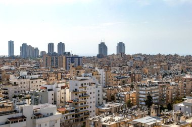 Yüksek binaları ve otelleri olan şehir yaz günlerinde gökyüzünün arka planında
