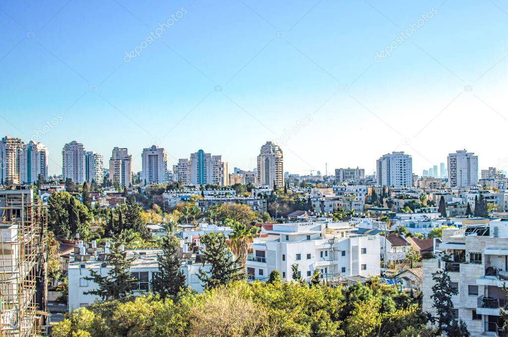 City with private houses and high-rise buildings on a background of sky in summer daytime