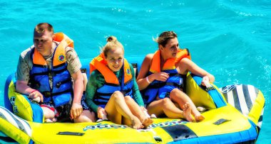 El Gouna / Mısır - 11 Nisan 2015: Deniz eğlencesi, mutlu insanlar şişme su teknesine biniyor